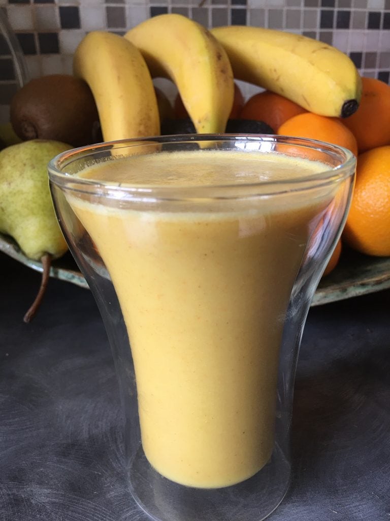Glass filled with a golden yellow smoothie