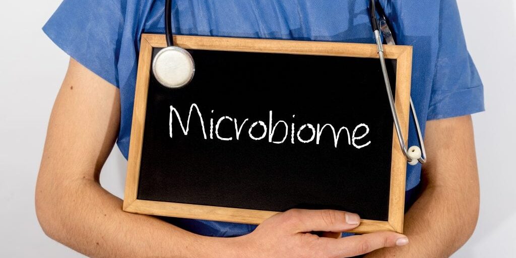 A Doctor holding a sign about the Microbiome as if getting ready to lecture about the microbiome