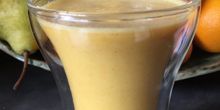 Glass filled with a golden yellow smoothie